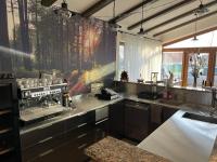 una cocina con fregadero y estufa horno superior en Tekeres-patak Fogadó, en Pálosvörösmart