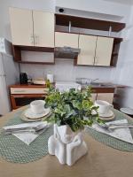 a kitchen table with a vase with a plant on it at Apartman Sany in Bihać
