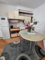 a kitchen with a table with a vase of flowers on it at Apartman Sany in Bihać