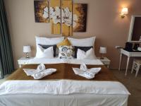 a bedroom with a large white bed with white bows on it at Calimbra Wellness Hotel Superior in Miskolctapolca