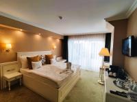 a hotel room with a large bed with a television at Calimbra Wellness Hotel Superior in Miskolctapolca