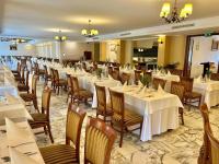 a dining room with white tables and chairs at Calimbra Wellness Hotel Superior in Miskolctapolca