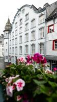 a white building with pink flowers in front of it at Hotel Royal in Monschau