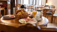 a table with a basket of bread and a basket of orange juice at Hotel Royal in Monschau