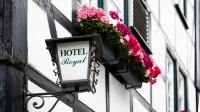 a sign on the side of a building with flowers at Hotel Royal in Monschau