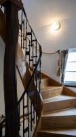 a wooden staircase with a black metal railing at Hotel Royal in Monschau