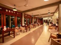 Un restaurante con mesas y sillas de madera en un edificio. en Aramya river front boutique hotel, en Kitulgala