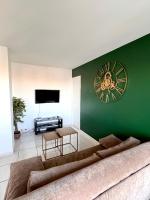 ein Wohnzimmer mit einer großen Uhr an einer grünen Wand in der Unterkunft The Sunrise ~ Spacious, fully equipped &amp; parking in Montpellier