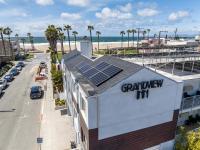 a building with solar panels on the roof next to the beach at Grandview Inn in Hermosa Beach