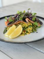 Un plato de comida con pescado y maíz y un limón. en International Hotel Wagga Wagga, en Wagga Wagga