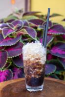 a drink sitting on a table next to a plant at Kara Homestay & Cafe in Can Tho