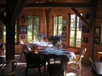 ein Esszimmer mit Tisch und Stühlen und Fenstern in der Unterkunft Residences Du Golf Des Roucous in Sauveterre