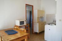 a small kitchen with a table and a microwave at Residence Thalassa in Calvi
