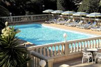 a swimming pool with chairs and umbrellas on a balcony at Residence Thalassa in Calvi