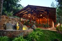 einem Holzpavillon mit einem Brunnen im Garten in der Unterkunft Sereno Chikmagalur in Chikmagalur
