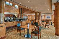 a restaurant with tables and chairs in a room at Crowne Plaza Bahrain by IHG in Manama