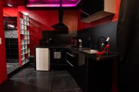 a kitchen with red and black walls and a sink at Suite Romantique in Narbonne