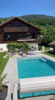 a swimming pool in front of a house at Chalet avec vue panoramique sur les Montagnes du Mole et la chaîne des Aravis piscine chauffée à 5 min des pistes de la station des Brasses in Viuz-en-Sallaz