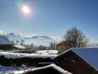 a snow covered roof of a house with the sun overhead at Chalet avec vue panoramique sur les Montagnes du Mole et la chaîne des Aravis piscine chauffée à 5 min des pistes de la station des Brasses in Viuz-en-Sallaz