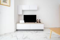 a living room with a tv on a white wall at Msida Central Suites in Msida