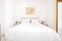 a white bed with white sheets and pillows at Msida Central Suites in Msida