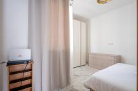 a bedroom with a bed and a white curtain at Msida Central Suites in Msida