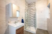 a bathroom with a sink and a glass shower at Msida Central Suites in Msida