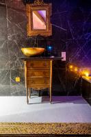 a bathroom with a sink and a mirror on a dresser at Suite Romantique in Narbonne