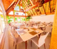 een restaurant met houten plafonds en tafels en stoelen bij Hotel Caribbean Coral in San Andrés