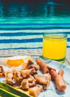 een bord met eieren en wortels naast een zwembad bij Hotel Caribbean Coral in San Andrés