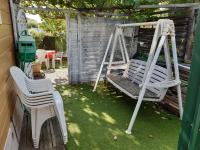 a yard with two white chairs and a swing at Un coin de paradis in Martigues
