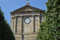 a building with a clock on the top of it at Contact Hôtel du Commerce et son restaurant Côte à Côte in Autun