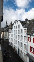 a white building with people walking in front of it at Hotel Royal in Monschau