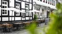 an outdoor restaurant with tables and chairs and umbrellas at Hotel Royal in Monschau