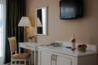 a hotel room with a desk with a television on the wall at Calimbra Wellness Hotel Superior in Miskolctapolca