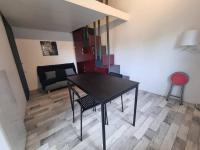 einen schwarzen Tisch und Stühle im Wohnzimmer in der Unterkunft Le Guichard - Wifi - Parking - Terrasse in Clermont-Ferrand