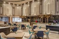 a restaurant with tables and chairs and chandeliers at Imperial Lexis Kuala Lumpur in Kuala Lumpur