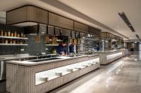 a chef preparing food in a large kitchen at Imperial Lexis Kuala Lumpur in Kuala Lumpur