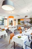 a restaurant with white tables and orange chairs at Domaine Lyon Saint Joseph in Sainte-Foy-lès-Lyon
