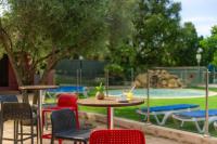 eine Terrasse mit Tischen und Stühlen sowie einem Spielplatz in der Unterkunft Camping Acqua E Sole in Sainte-Lucie de Porto-Vecchio