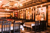 een restaurant met tafels en stoelen en foto's aan de muur bij Aynur Qala Resort in Quba