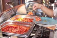 Iemand plaatst een schaal met eten op dienbladen. bij Aynur Qala Resort in Quba