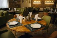 a wooden table with plates and utensils on it at Хижа Марциганица in Asenovgrad