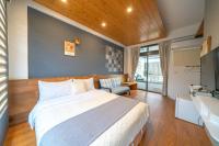 a bedroom with a large bed and a television at Field Trail Homestay in Jiaoxi