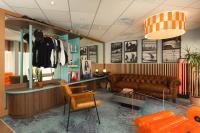 una sala de estar con un sofá y una mesa en Hôtel AKENA Biarritz - Grande plage, en Biarritz