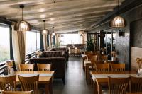 un ristorante con tavoli, divani e sedie di Готель Logindariy a Rokosovo