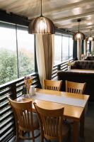 una sala da pranzo con tavolo, sedie e finestre di Готель Logindariy a Rokosovo