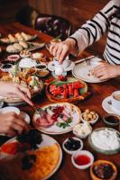 ウルダグにあるKarinna Orman Evleriの食べ物を囲んでテーブルの周りに座っている人々のグループ