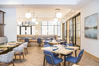 een restaurant met tafels, stoelen en ramen bij Hyatt Regency Coralville in Coralville