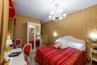 a bedroom with a bed and a chandelier at Hotel Il Mercante di Venezia in Venice